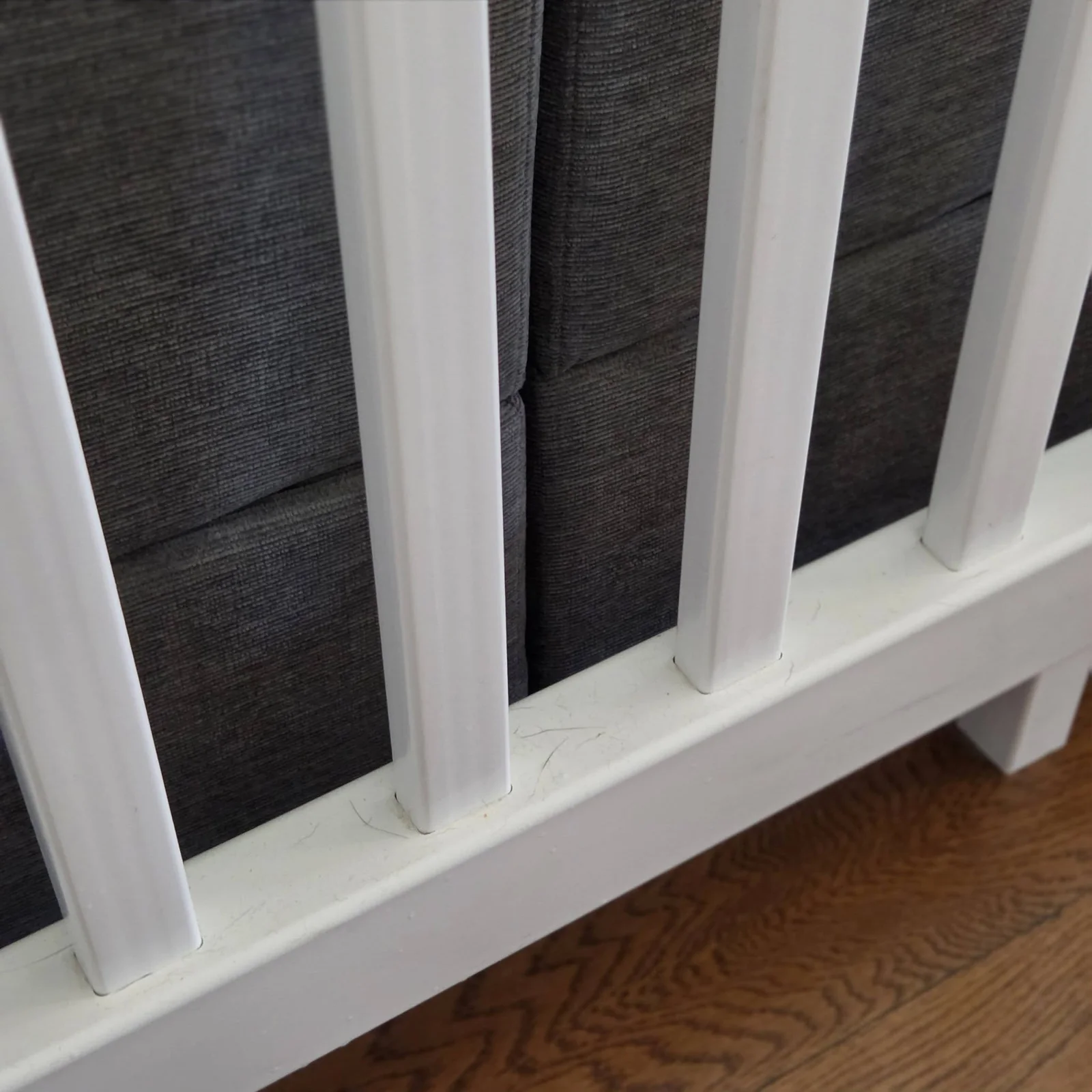 Hair and dust collected around a white railing base before detailed cleaning